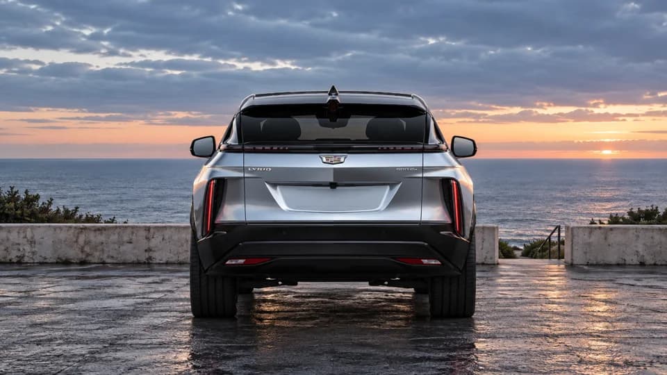 Silver Cadillac rear view overlooking the coast at sunset