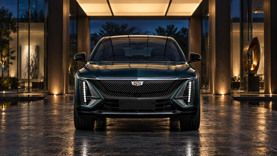 Dark Cadillac front view under illuminated architecture